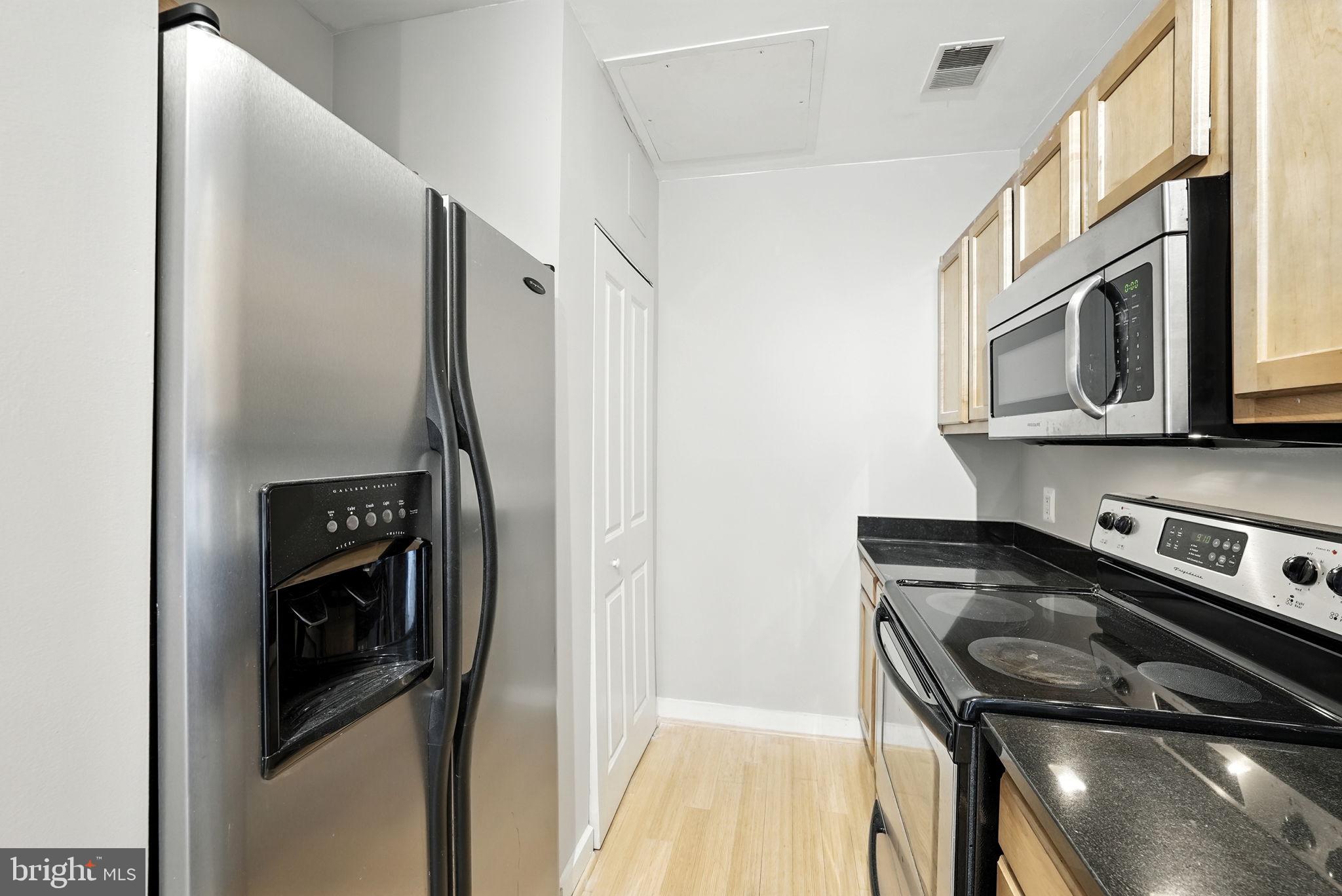 5885 Colorado Avenue Northwest, Unit 402 Washington, DC 20011 - Photo 18 of 30 a kitchen with stainless steel appliances granite countertop cabinets and a stove top oven
