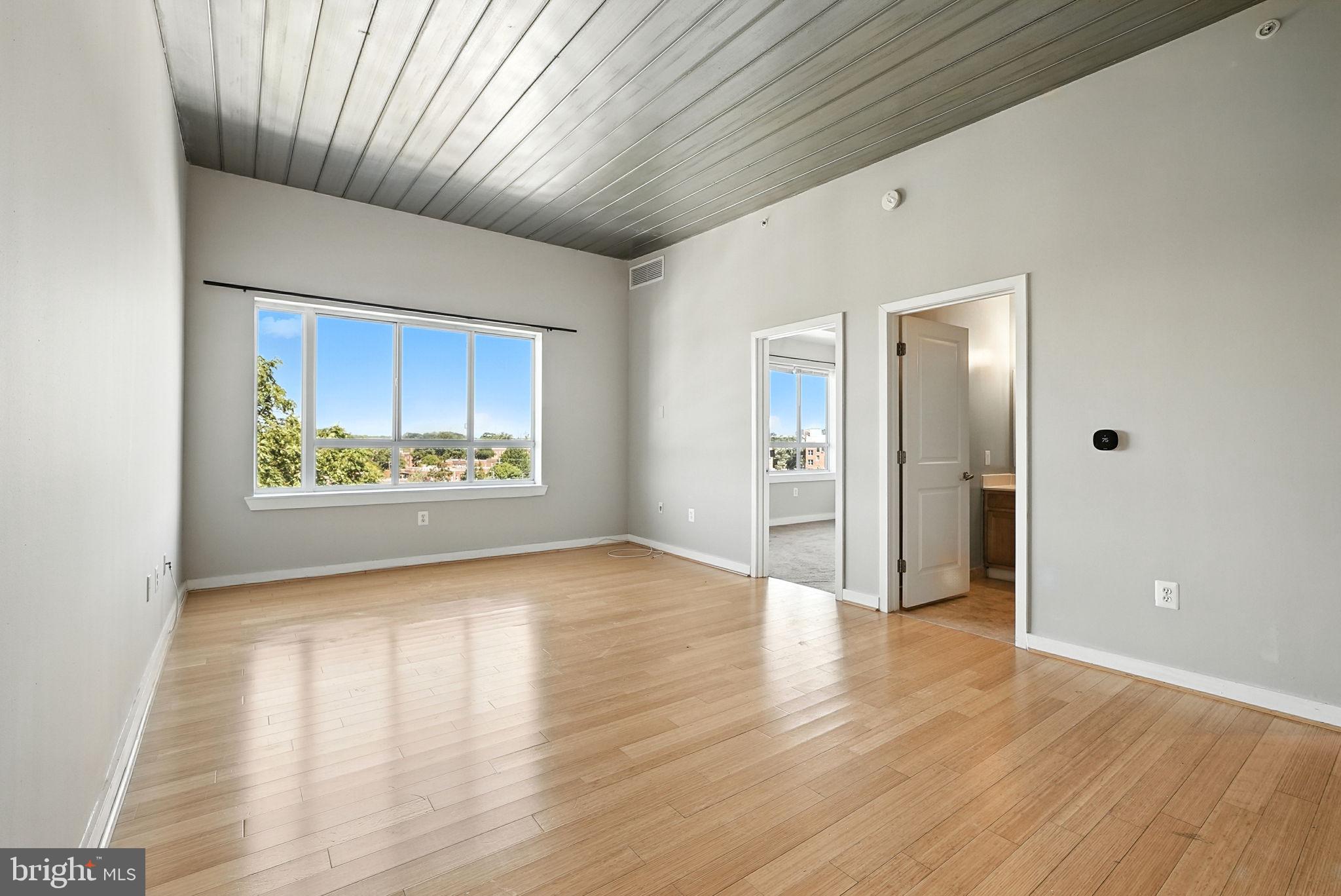 5885 Colorado Avenue Northwest, Unit 402 Washington, DC 20011 - Photo 3 of 30 a view of an empty room with wooden floor and a window