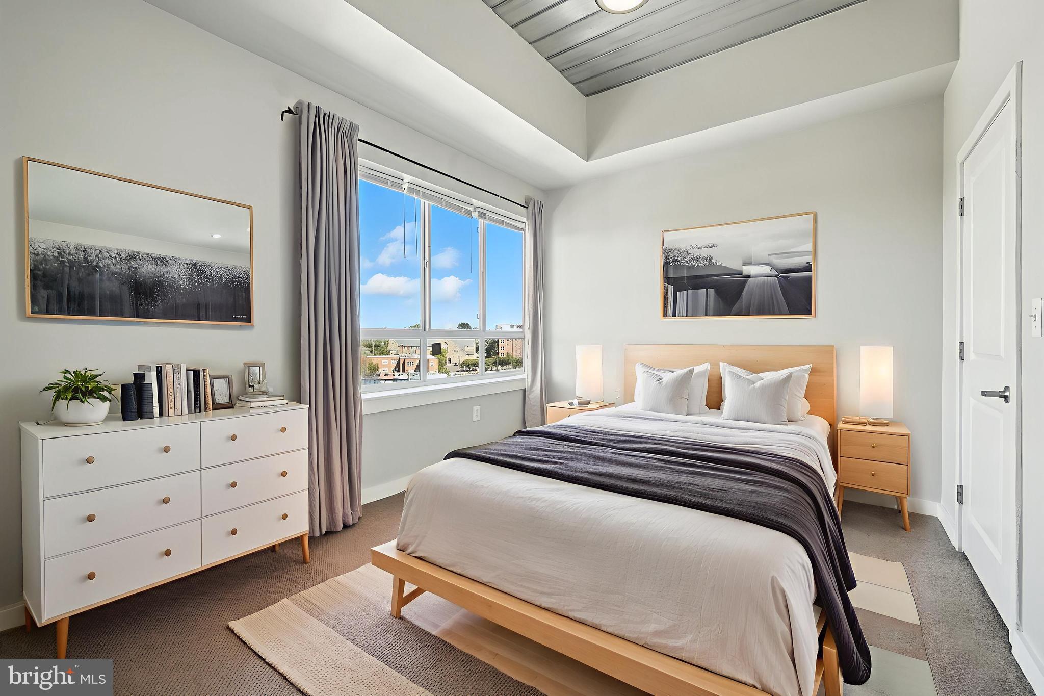 5885 Colorado Avenue Northwest, Unit 402 Washington, DC 20011 - Photo 8 of 30 a bedroom with a large bed and a flat tv screen on dresser