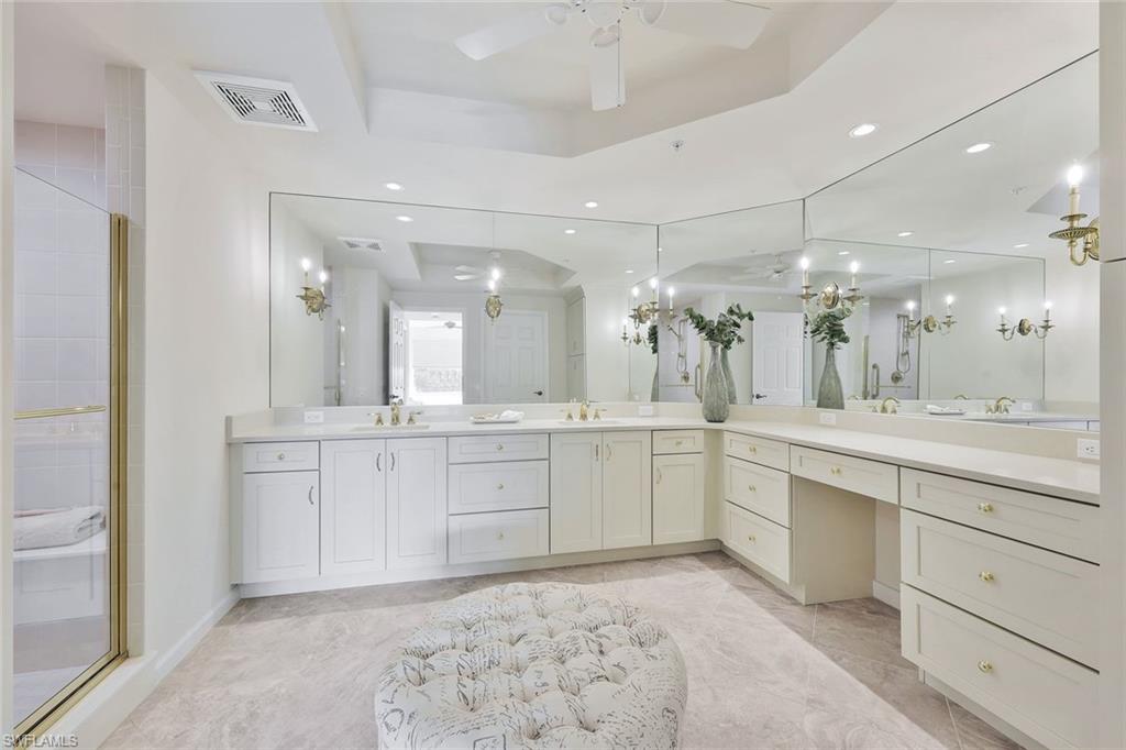 445 Cove Tower Drive, Unit 403 Naples, FL 34110 - Photo 13 of 42 a large bathroom with a sink a large mirror and a shower