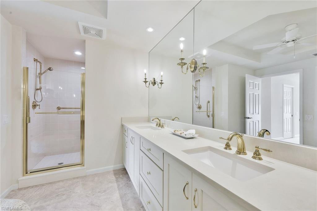 445 Cove Tower Drive, Unit 403 Naples, FL 34110 - Photo 14 of 42 a spacious bathroom with a double vanity sink mirror and shower