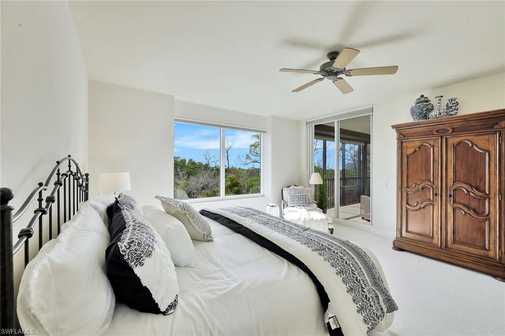 445 Cove Tower Drive, Unit 403 Naples, FL 34110 - Photo 15 of 42 a bed sitting in a bedroom next to a window