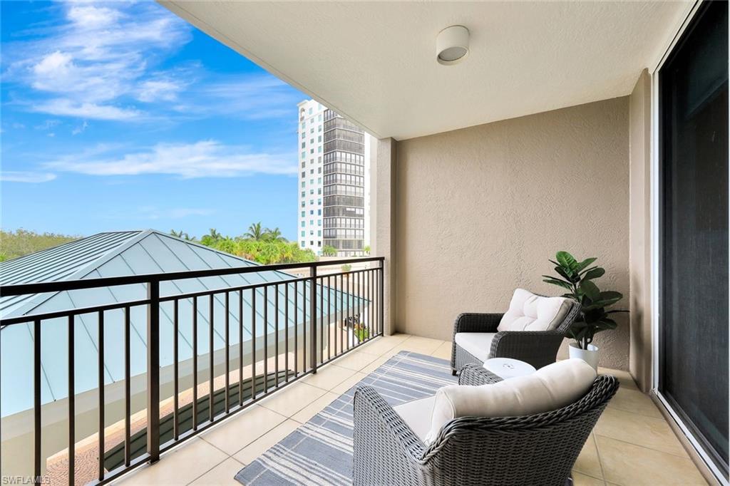 445 Cove Tower Drive, Unit 403 Naples, FL 34110 - Photo 23 of 42 a balcony with furniture and a potted plant
