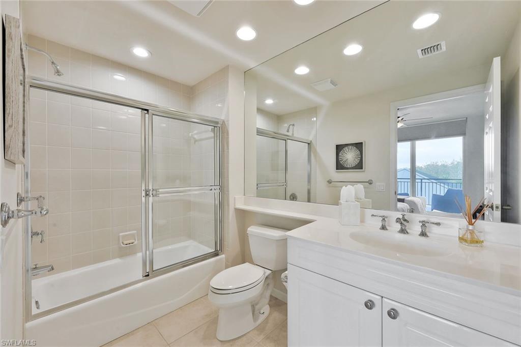 445 Cove Tower Drive, Unit 403 Naples, FL 34110 - Photo 26 of 42 a bathroom with a sink a toilet and shower