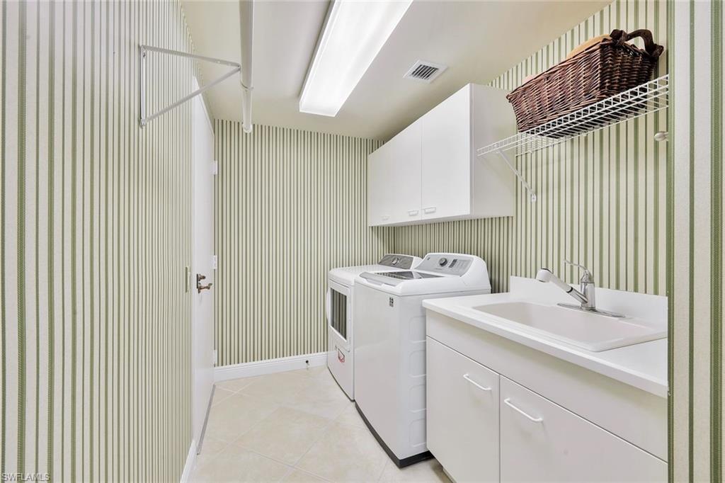 445 Cove Tower Drive, Unit 403 Naples, FL 34110 - Photo 27 of 42 a utility room with dryer and washer