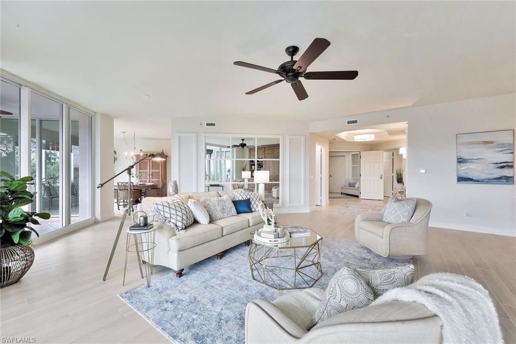 445 Cove Tower Drive, Unit 403 Naples, FL 34110 - Photo 4 of 42 a living room with furniture and a wooden floor