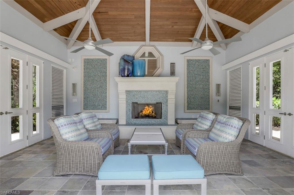 445 Cove Tower Drive, Unit 403 Naples, FL 34110 - Photo 42 of 42 a living room with furniture and a fireplace