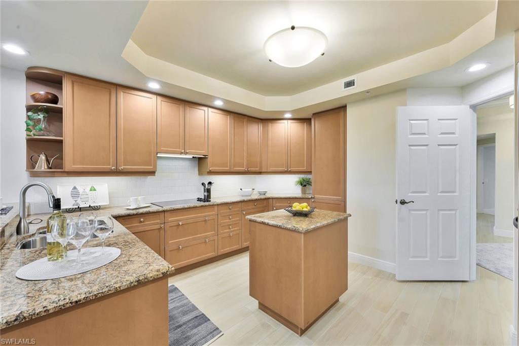 445 Cove Tower Drive, Unit 403 Naples, FL 34110 - Photo 7 of 42 a kitchen with stainless steel appliances granite countertop a sink stove and refrigerator
