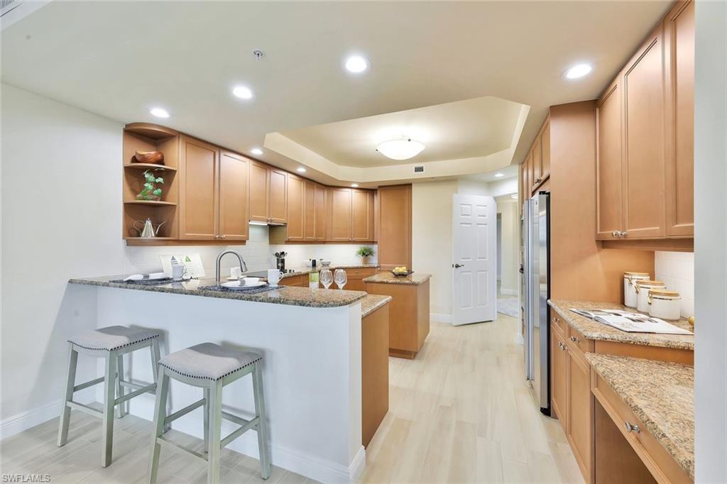 445 Cove Tower Drive, Unit 403 Naples, FL 34110 - Photo 8 of 42 a kitchen with sink cabinets and stove