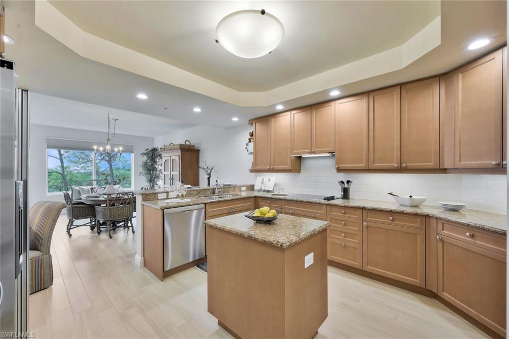 445 Cove Tower Drive, Unit 403 Naples, FL 34110 - Photo 9 of 42 a kitchen with a sink stove and cabinets