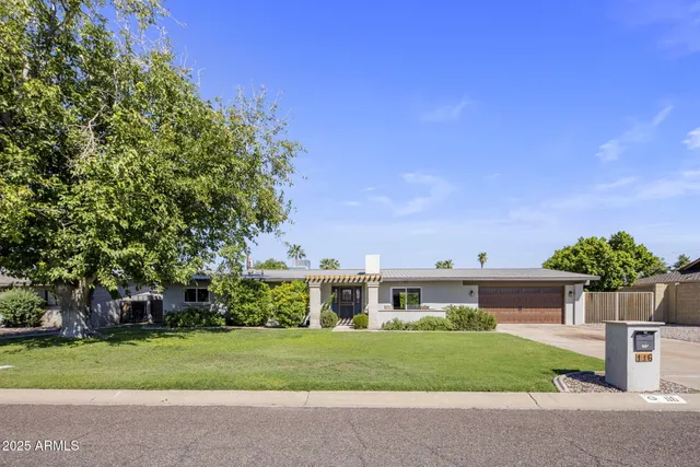 a front view of a house with a yard and a garage