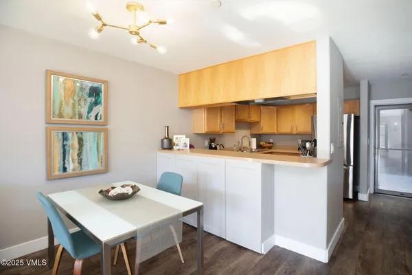 a kitchen with a table chairs refrigerator and cabinets