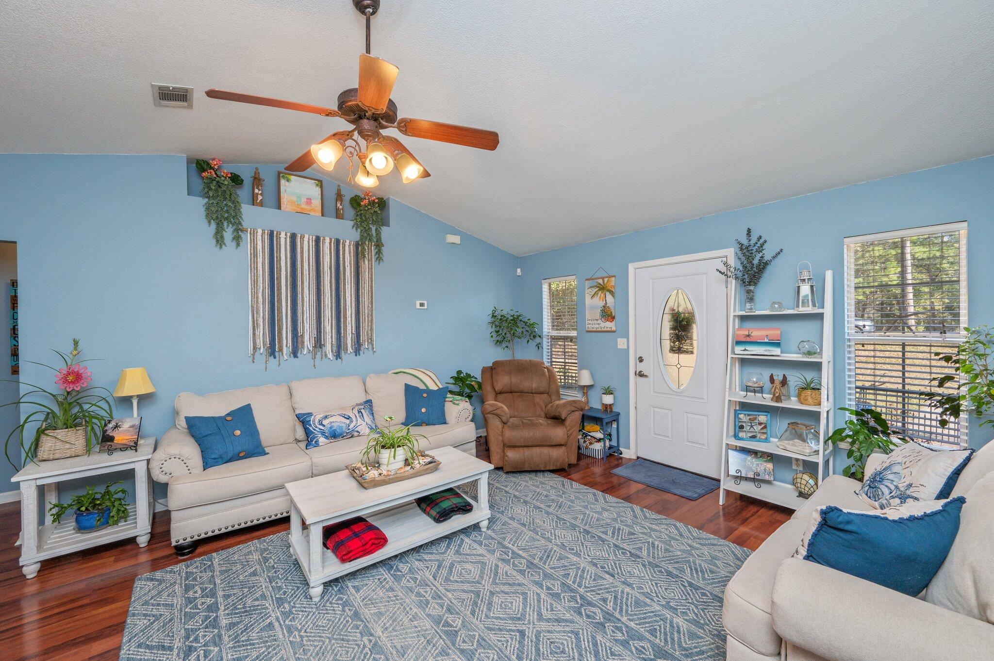 8933 Highway 90 Milton, FL 32583 - Photo 19 of 31 a living room with furniture a rug and a chandelier