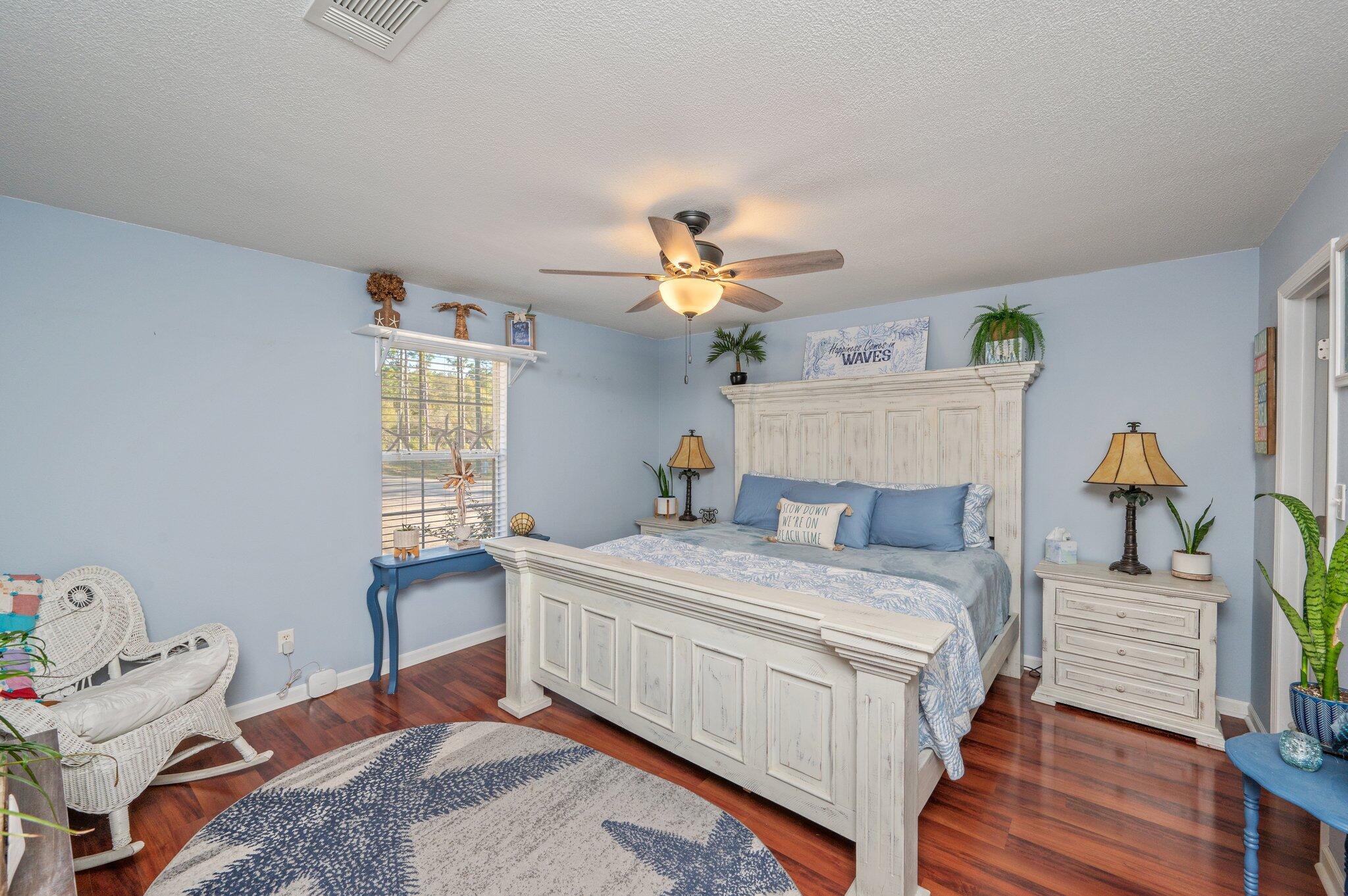 8933 Highway 90 Milton, FL 32583 - Photo 5 of 31 a bedroom with a bed and wooden floor