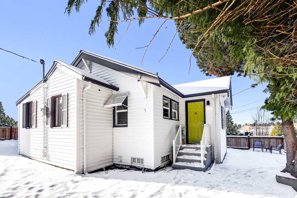 a view of a white house with wooden walls and floor to ceiling windows