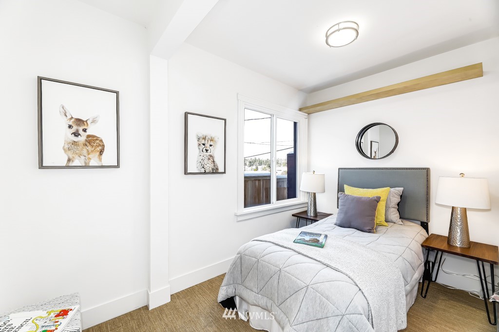 2117 Southwest Trenton Street Seattle, WA 98106 - Photo 12 of 18 a bedroom with a bed and painting on the wall