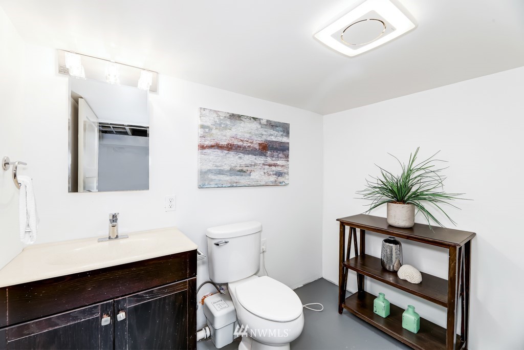 2117 Southwest Trenton Street Seattle, WA 98106 - Photo 17 of 18 a bathroom with a toilet a sink and mirror
