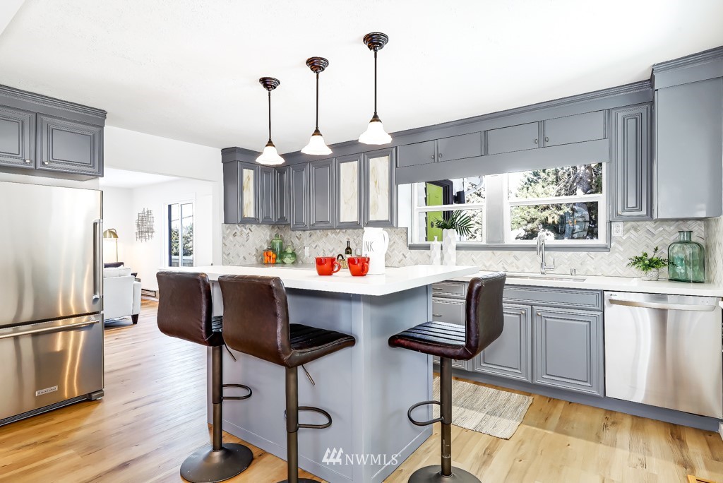 2117 Southwest Trenton Street Seattle, WA 98106 - Photo 4 of 18 a kitchen with granite countertop a counter space dining table and stainless steel appliances