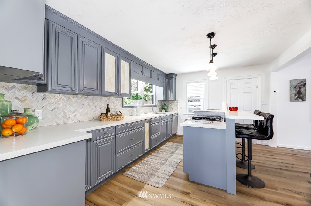 2117 Southwest Trenton Street Seattle, WA 98106 - Photo 5 of 18 a kitchen that has a lot of cabinets in it and wooden floors