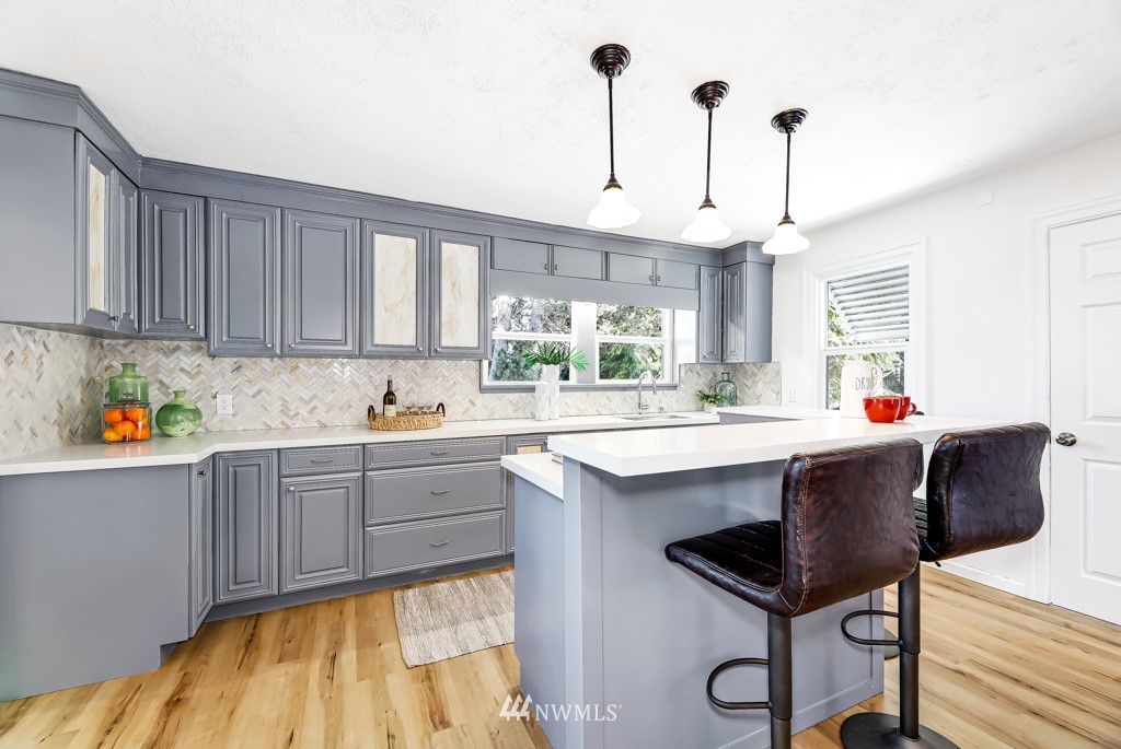 2117 Southwest Trenton Street Seattle, WA 98106 - Photo 6 of 18 a kitchen with a table chairs sink and cabinets