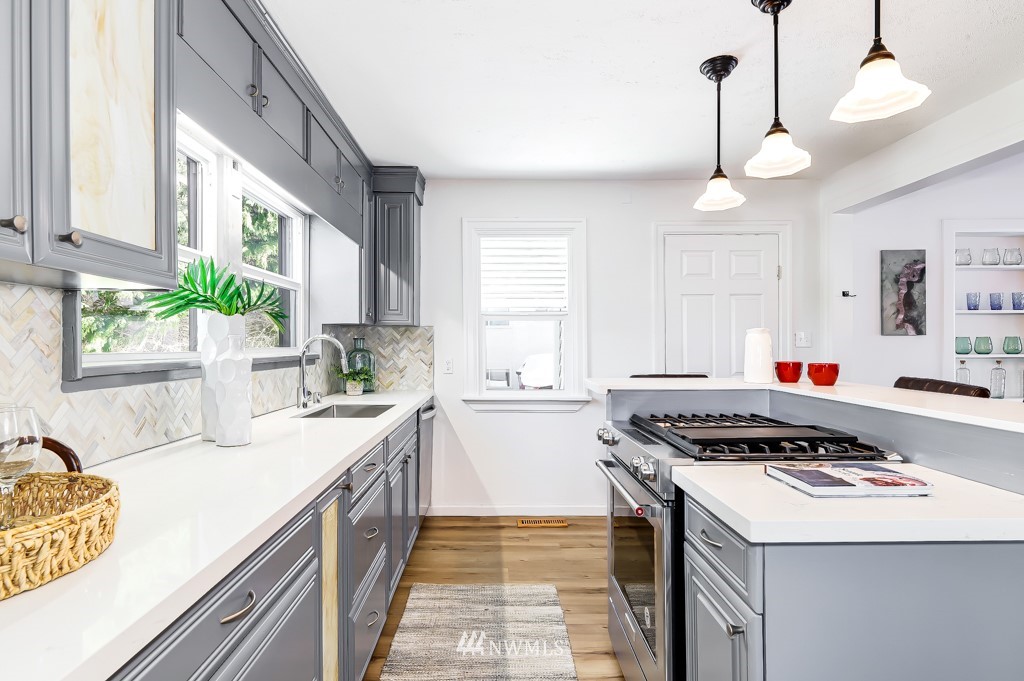 2117 Southwest Trenton Street Seattle, WA 98106 - Photo 7 of 18 a kitchen with a stove a sink a window and cabinets