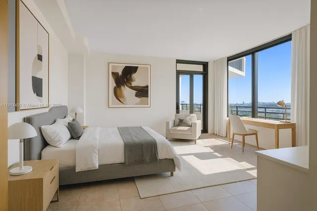 a bedroom with a bed and a large window