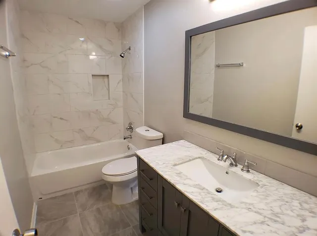 a bathroom with a granite countertop sink and a mirror