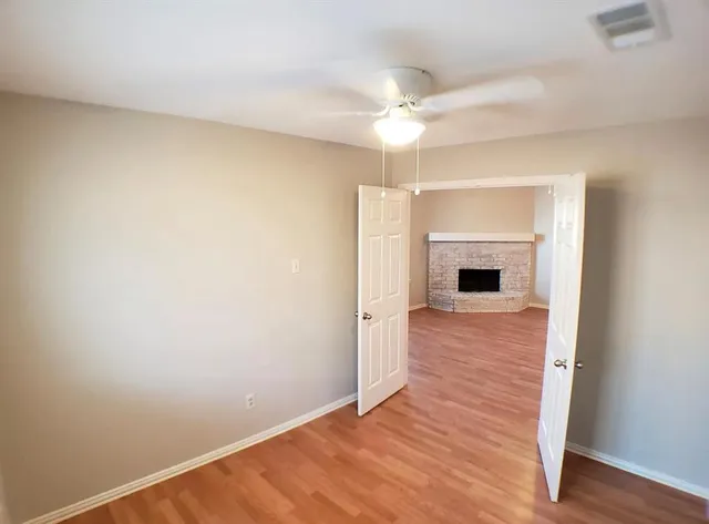 a view of empty room with wooden floor and fireplace