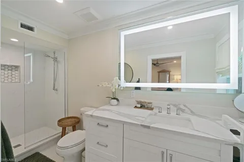 a bathroom with a granite countertop sink a toilet and a mirror
