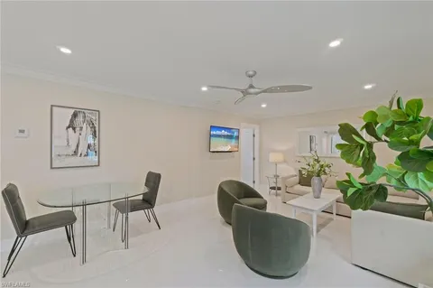 a living room with furniture a window and a potted plant