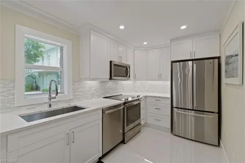 a kitchen with white cabinets and stainless steel appliances