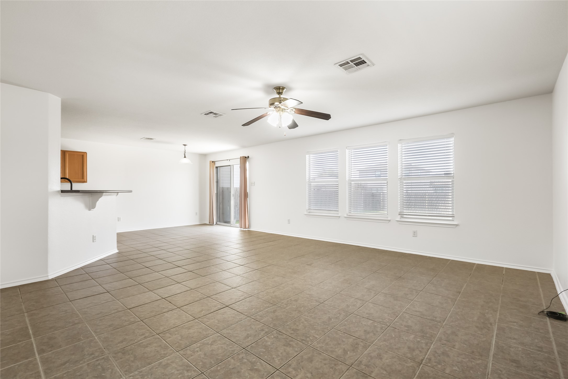 2010 Ashberry Trail Georgetown, TX 78626 - Photo 6 of 24 Unfurnished living room featuring ceiling fan and dark tile patterned floors
