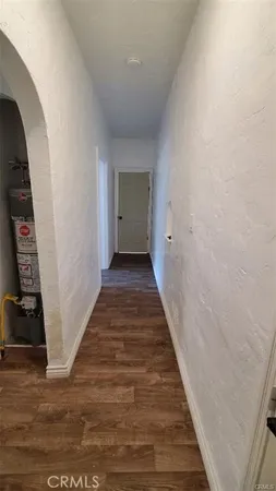 a view of a hallway with wooden floor and closet