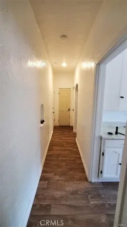 a view of a hallway with wooden floor