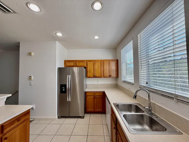a kitchen with a refrigerator sink and cabinets