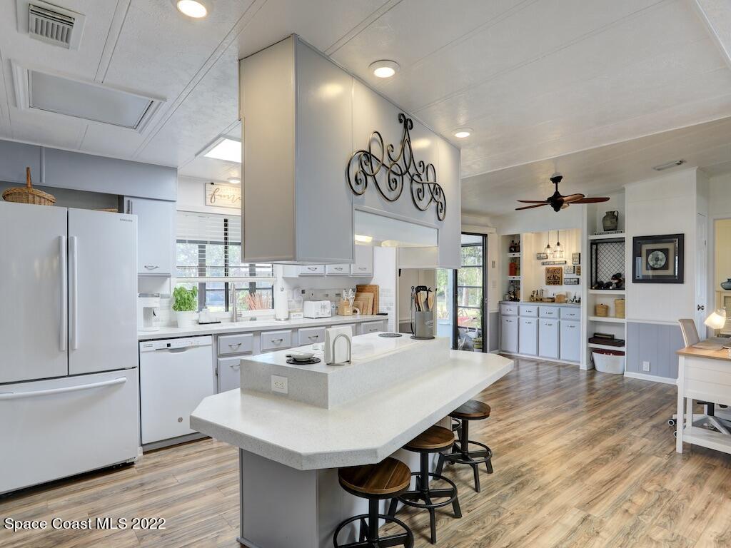 727 Periwinkle Drive Sebastian, FL 32976 - Photo 13 of 34 a kitchen with a dining table chairs refrigerator and cabinets
