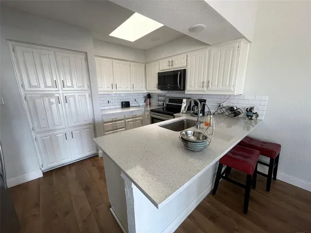 a kitchen with sink cabinets and wooden floor