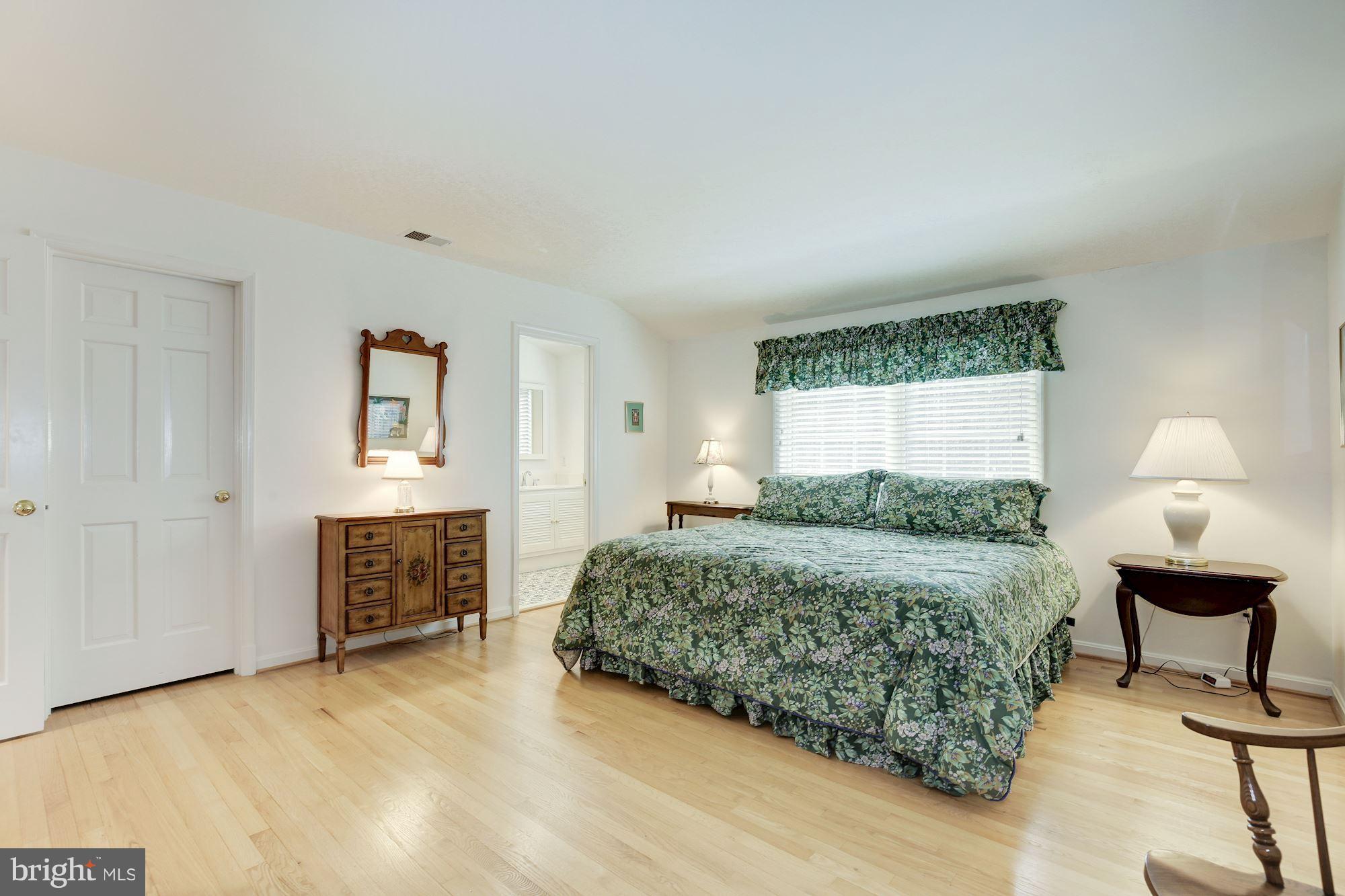 8821 Belmart Road Potomac, MD 20854 - Photo 19 of 29 a bedroom with a bed and a chandelier