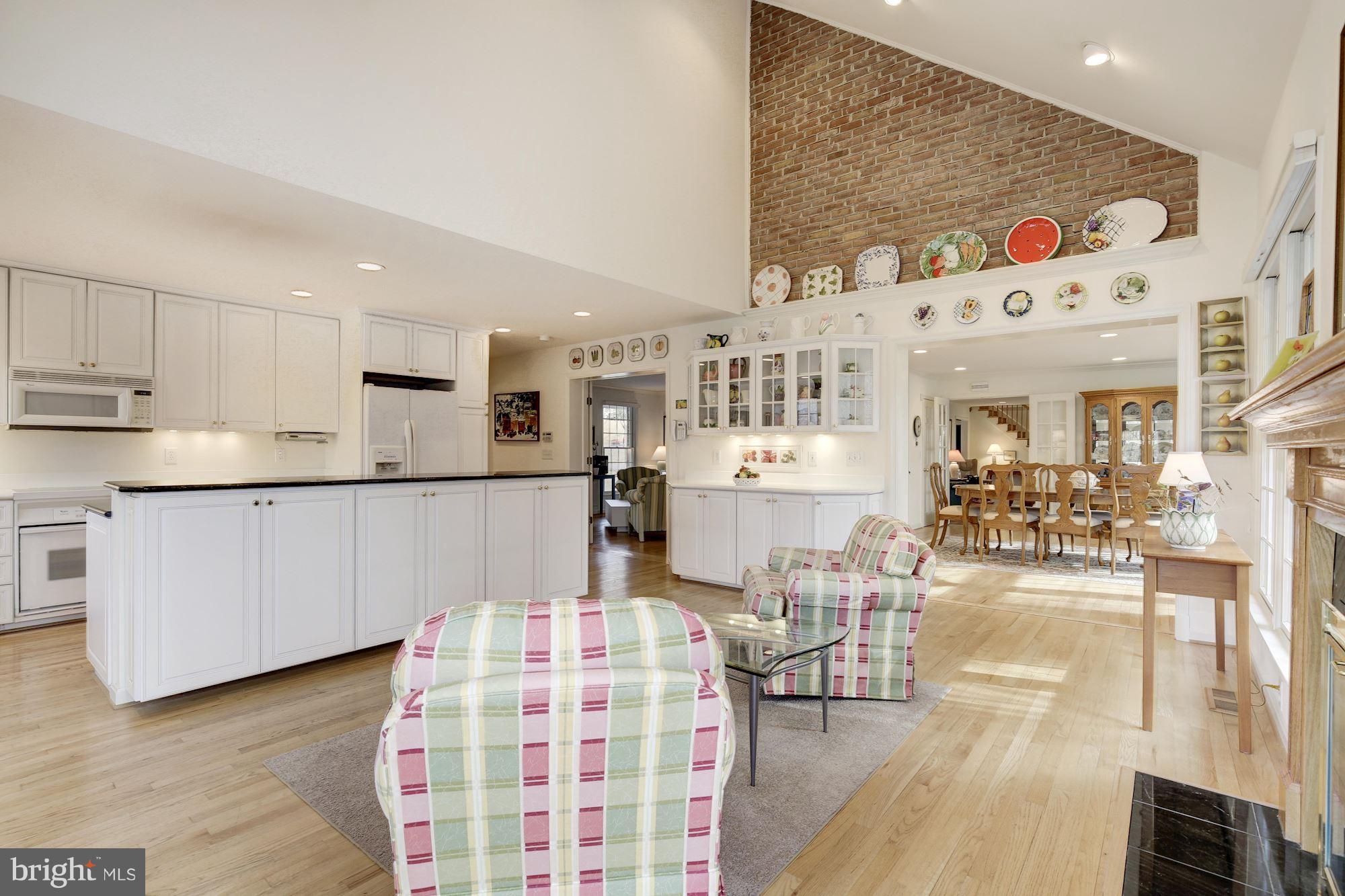8821 Belmart Road Potomac, MD 20854 - Photo 6 of 29 a living room with kitchen island furniture and a wooden floor