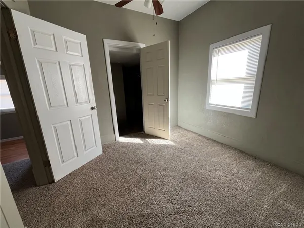 an empty room with windows and closet