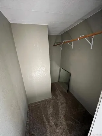 a view of a room with wooden floor and a ceiling fan