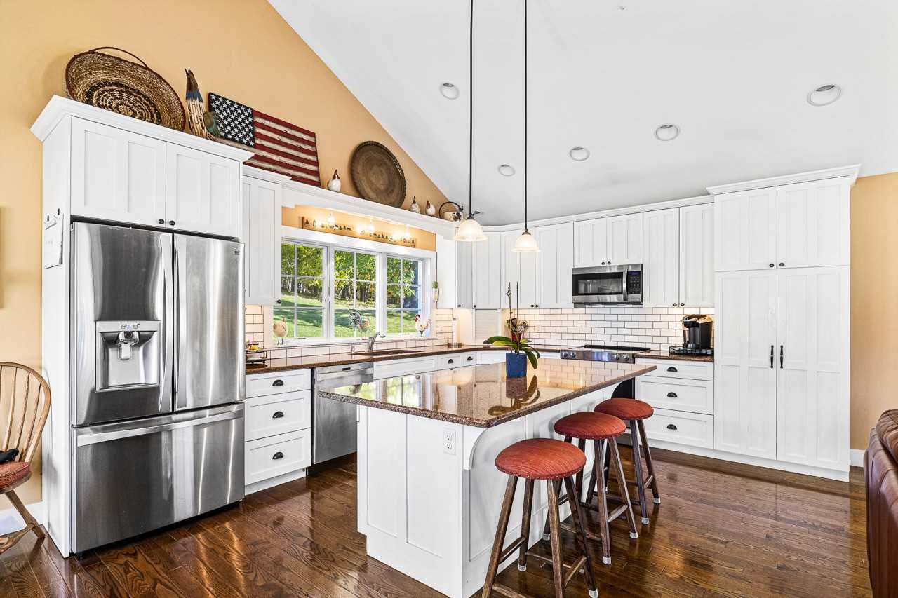 368 Skiba Road Gallatin, NY 12523 - Photo 11 of 40 a kitchen with stainless steel appliances a refrigerator a stove a sink and white cabinets with wooden floor