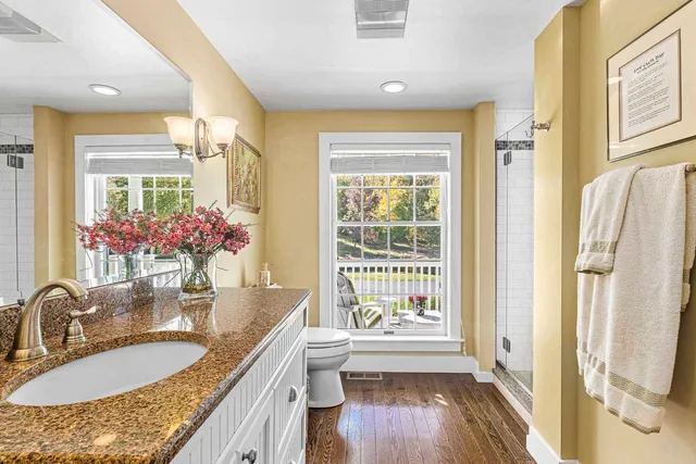a bathroom with a granite countertop sink a mirror and a shower
