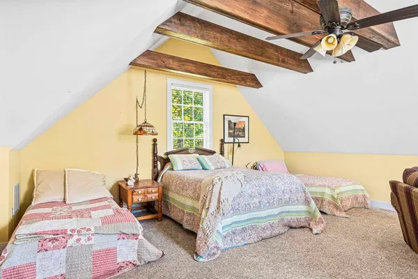 a bedroom with a bed lamp and a large window