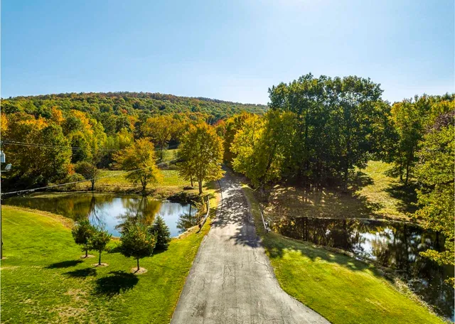 a view of a swimming pool with an outdoor seating and a lake view