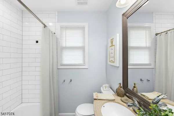 a bathroom with a granite countertop sink toilet a mirror and shower