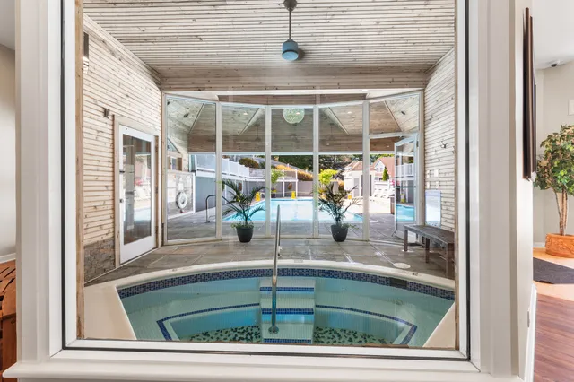 a room with a floor to ceiling window and pool