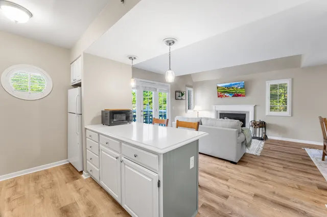 a room with kitchen island a wooden floor and a chandelier