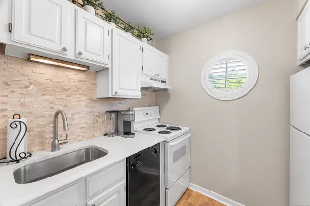 a kitchen with stainless steel appliances granite countertop a sink a stove and cabinets