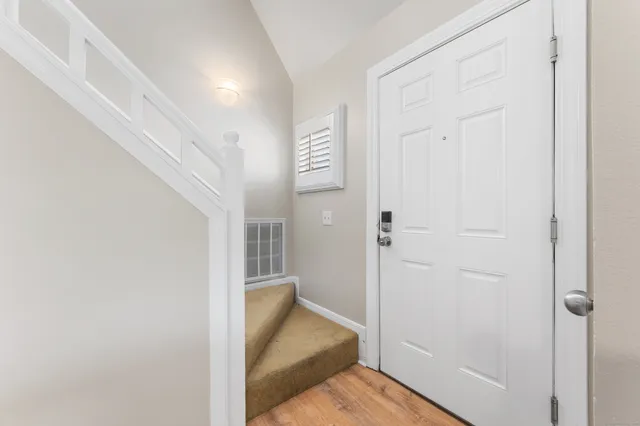 a view of a hallway with wooden floor and closet